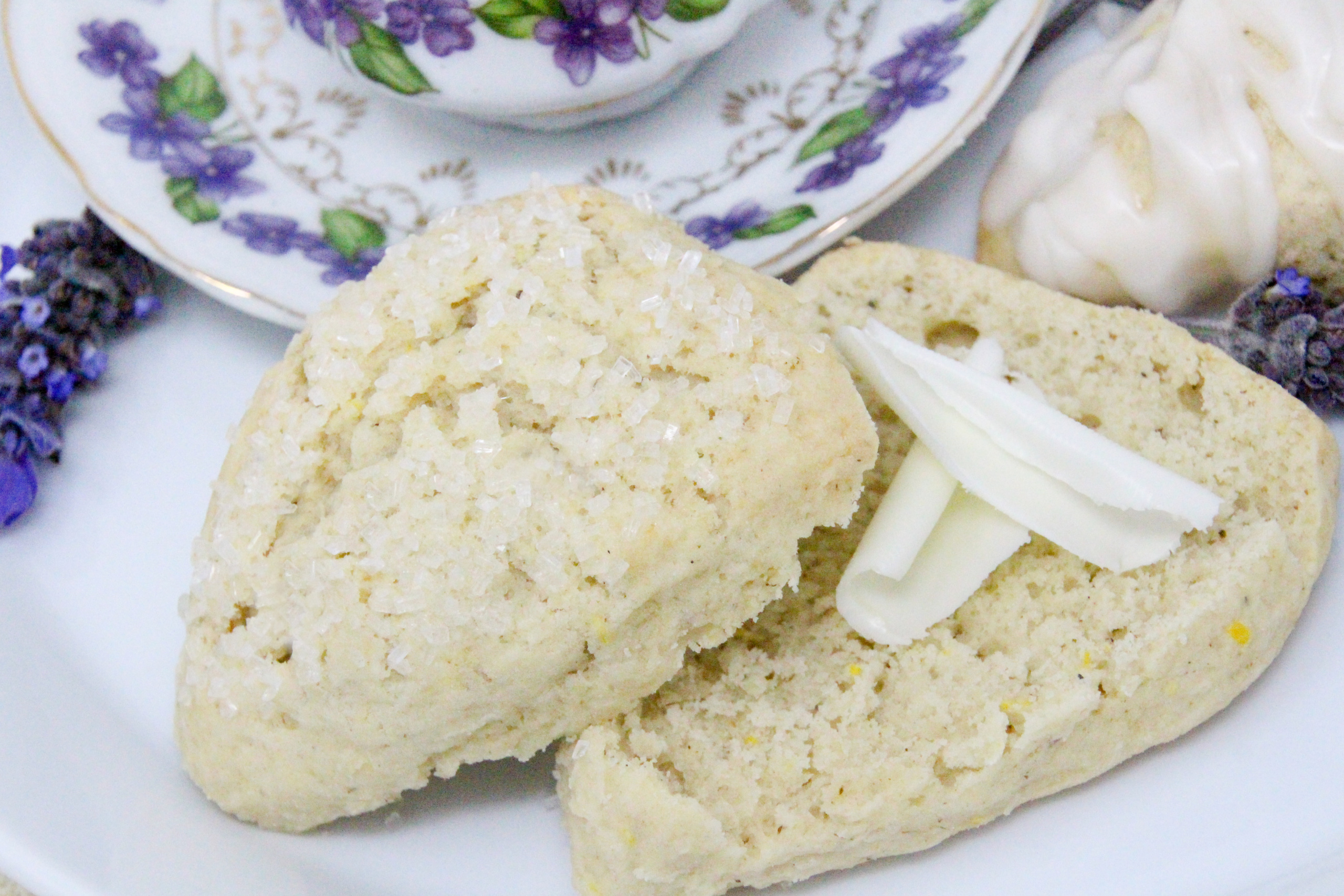 Lavender Buttermilk Scones uses the process of grating the cold butter into the flour mixture to make the scones tender. With the addition of lemon zest alongside the lavender and a drizzle of lavender lemon icing over the tops, these delectable scones were scrumptious! Recipe shared with permission granted by Leslie Budewitz, author of LAVENDER LIES BLEEDING.